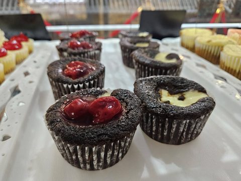 Chocolate cheesecake cupcakes, some topped with cherries