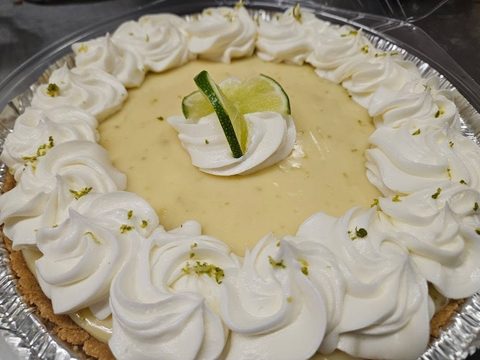 Key lime pie with whipped cream rosettes and a lime slice