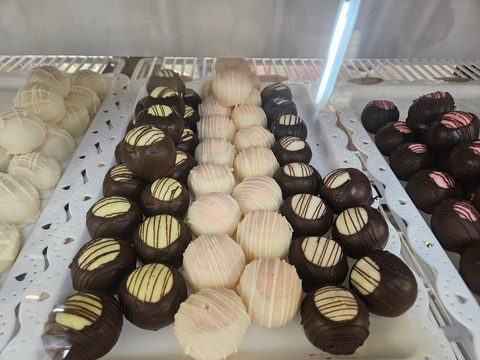 Chocolate-dipped and white-dipped round treats with drizzle